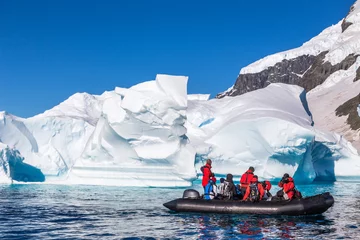 Tuinposter Boot vol toeristen verkennen enorme ijsbergen die in de baai drijven © vadim.nefedov