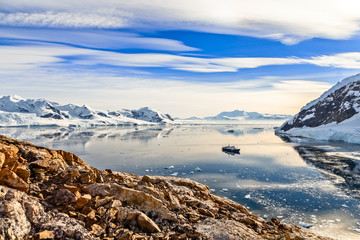 Fototapeta na wymiar Antarctic mountain landscape with cruise ship standing still in