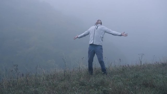 Frustrated depressed man in depression screams with anger standing alone in the fog,slow mo