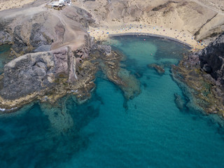 Vista aerea delle coste frastagliate e delle spiagge di Lanzarote, Spagna, Canarie.  Bagnanti in spiaggia e nell’Oceano Atlantico. Papagayo