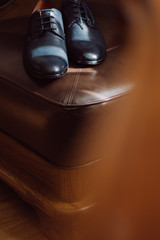men's leather shoes on a leather chair