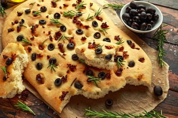 Homemade Italian focaccia with sun dried tomatoes, black olives and rosemary