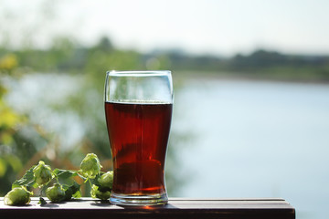glass of beer on the table by the river