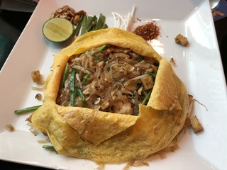 Chicken pad thai covered with a scrambled fried egg