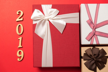 wood text year 2019 and gift box on red background for happy new year