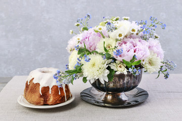 Floral arrangement with pink peonies, ranunculus flowers, white chrysanthemums, matricaria forget me not and bluebells (muscari).
