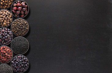 Dark spices on  blackboard with space for food recipe. background of condiments for labels or site caps