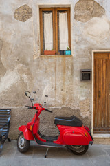 Fototapeta na wymiar Red scooter parked in Pitigliano, Tuscany