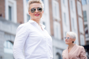 Portrait of successful business woman standing on background with blurred businesswoman