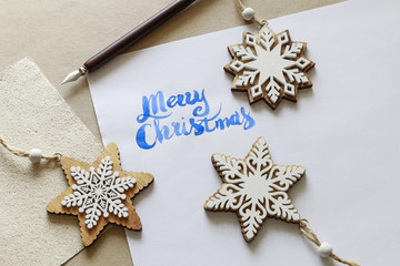 Merry Christmas - calligraphy, handwritten letters on white paper.