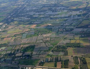 Fototapeta premium Aerial wide shot of rice fields seen while approaching Ho Chi Minh City in Vietnam.