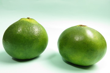 green tangerine on green background