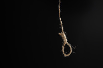 tiny brown noose on a black background