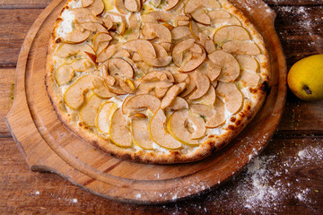 pizza with pear and gargantzolla on a wooden board