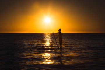 Silhouette of a man practicing stand-up paddle