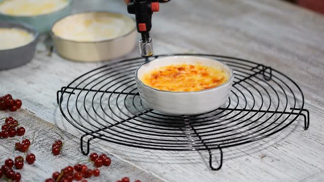 Burn portion of creme brulee dessert on kitchen. Delicious french dessert creme brulee.