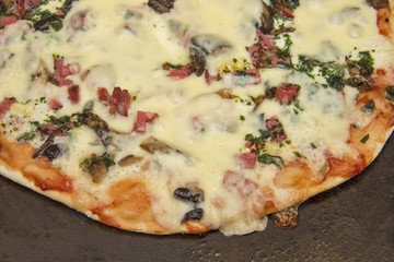 Pizza with mozzarella, fried mushrooms, sausage and parsley