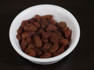close up of pile of raisins on white background, Kismish, Munnka, Kismish in Whitye Bowl on Wooden Background,Raisins in White Bowl on Wooden Background,