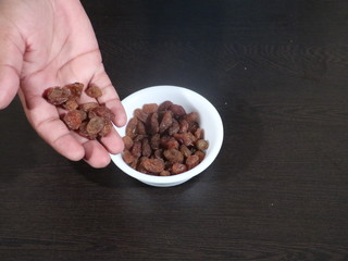 close up of pile of raisins on white background, Kismish, Munnka, Kismish in Whitye Bowl on Wooden Background,Raisins in White Bowl on Wooden Background,