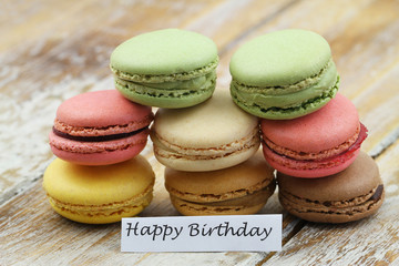 Happy birthday card with colorful macaroons on wooden surface
