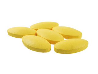 Close up of six yellow oval drugs isolated on a white background.In medicine for the treatment of disease