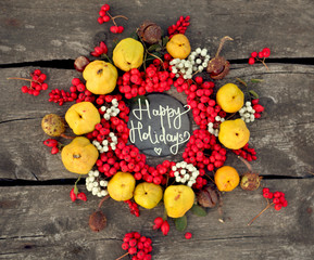 autumn background with rowan ,rose hip,chestnuts and quince on the rustic background