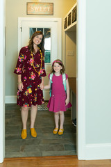 mom and daughter at garage door on first day of school