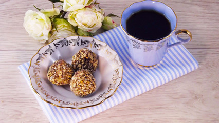 Fragrant coffee and chocolates on a light wooden background.