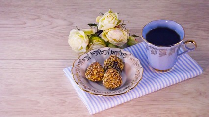 Fragrant coffee and chocolates on a light wooden background.