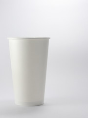 Close up of takeaway disposable white blank paper coffee cup mockup isolated on white background in front view.Disposable tableware is often used for hot drink in food stores