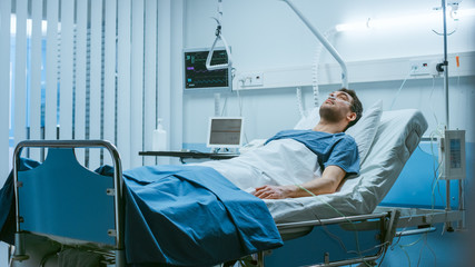 In the Hospital, Sick Male Patient Lies on a Bed, Fighting the Disease. Clean and Comfortable...