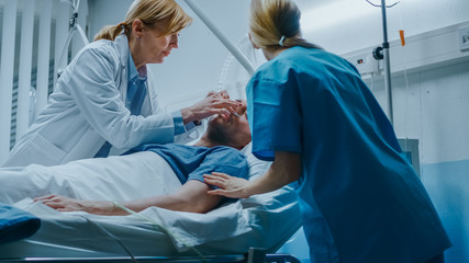 Emergency in the Hospital, Doctor and Nurse Rush into the Ward to Safe Dying Patient. Man is Lying on the Bed without Signs of Life. Doctors Do Everything to Resuscitate Him.