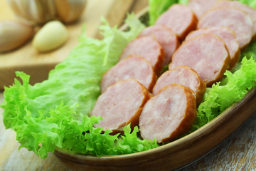 Slices of traditional Polish pork sausage on lettuce, closeup
