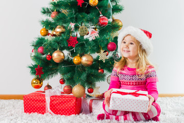 Happy Christmas Child With Gift Box And New Year Tree At Home