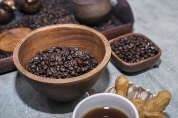 Coffee beans in a wooden Bowl on the wooden floor.