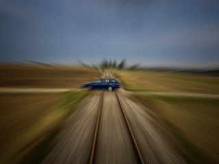 Train perspective of a car passing a railroad crossing with strong motion blur
