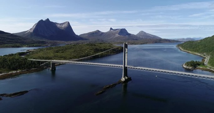 Aerial footage of a suspension bridge over Efjord with  mountain Stortinden in the background, Ballangen, Norway