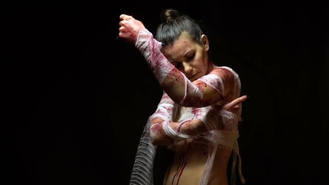 Woman bandaging wounds on body