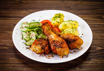 Grilled chicken drumsticks with boiled potatoes and vegetables