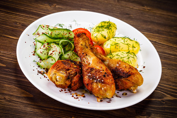 Grilled chicken drumsticks with boiled potatoes and vegetables