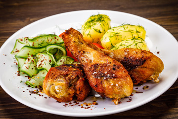 Grilled chicken drumsticks with boiled potatoes and vegetables