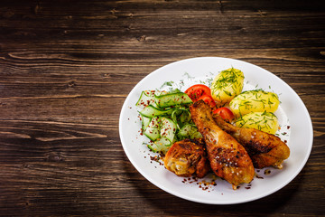 Grilled chicken drumsticks with boiled potatoes and vegetables