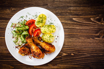 Grilled chicken drumsticks with boiled potatoes and vegetables