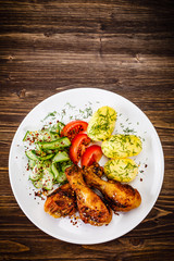 Grilled chicken drumsticks with boiled potatoes and vegetables