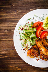 Grilled chicken drumsticks with boiled potatoes and vegetables