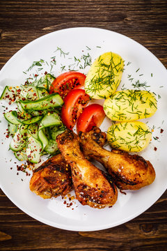 Grilled chicken drumsticks with boiled potatoes and vegetables