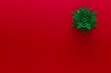 Green snowflake ornament on the up-right corner of a red background