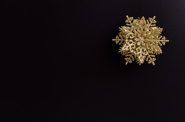 Golden snowflake christmas decoration on the up-right corner of a black background