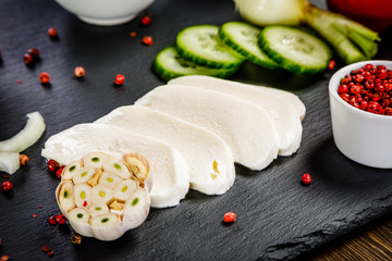 Vegetables for salad on black stone plate wooden background