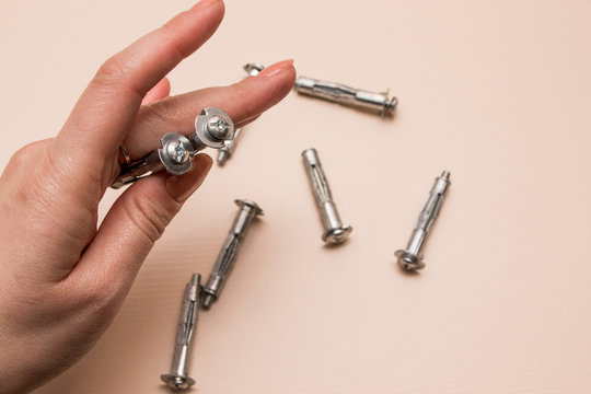 Wall plug or anchor or rawlplug in the hand  on a wooden background
